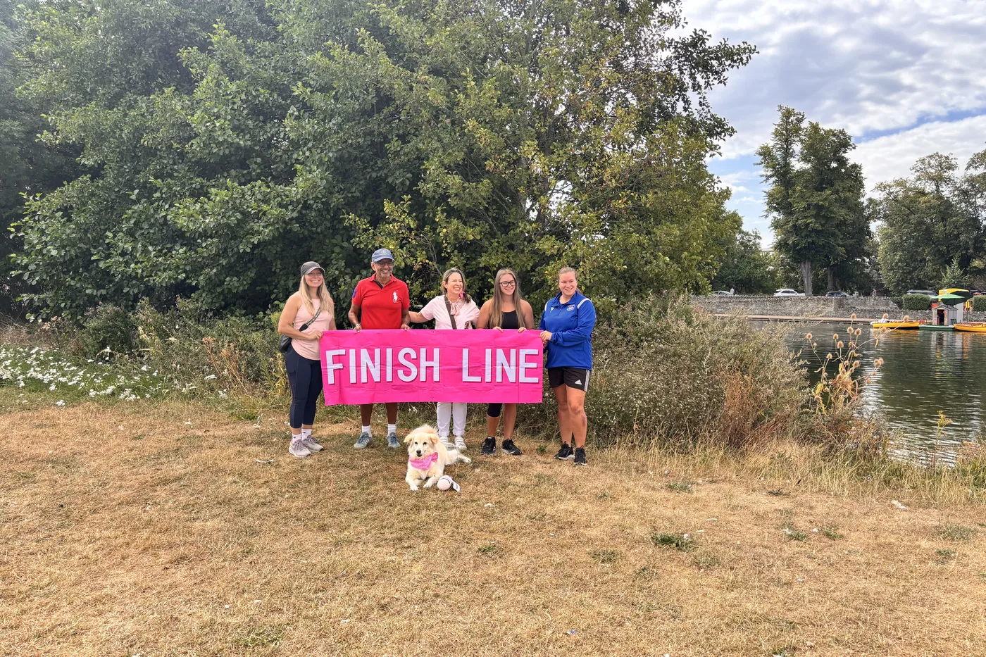 Crew members holding a pink Finish Line banner with Matilda in front