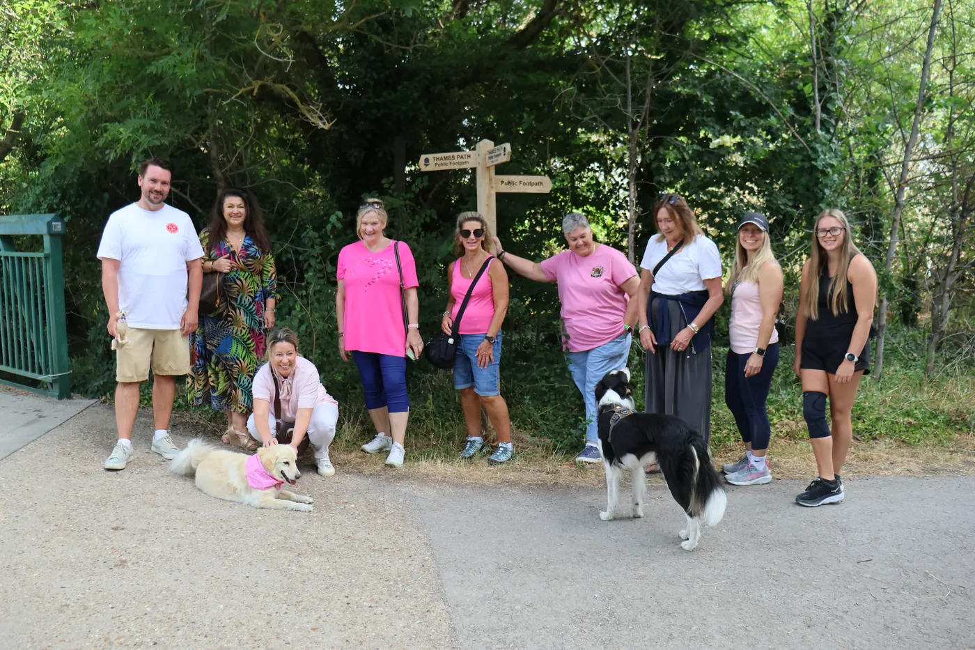 The crew gathered at a Thames Path signpost with Matilda and a collie